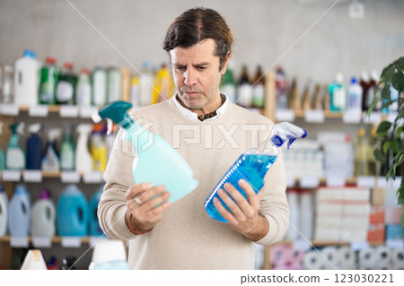 man chooses a spray to clean surfaces 123030221