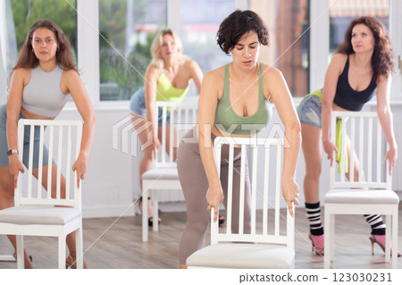 Woman practicing lap dance on chair at group modern choreography class 123030231