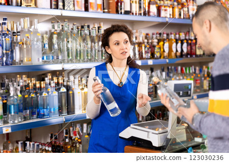 Adult woman seller offers vodka to man 123030236