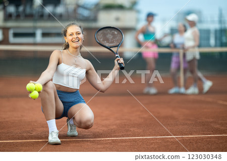 Young woman posing on tennis court 123030348