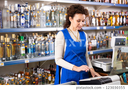 Adult saleswoman posing at store counter Adult saleswoman posing at store counter 123030355