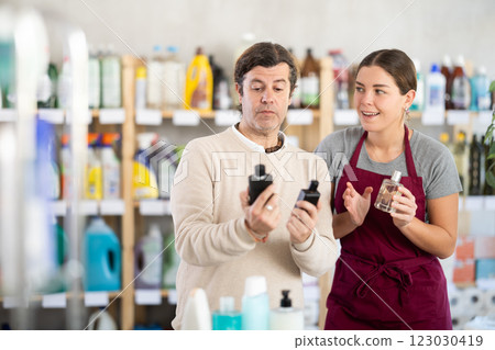 Female consultant helps man buyer choose perfume 123030419