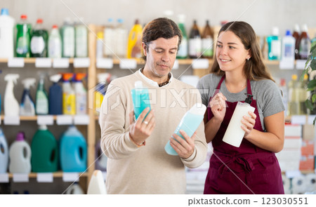 Female consultant helps man buyer choose shampoo or shower gel Female consultant helps man buyer choose shampoo or shower gel 123030551