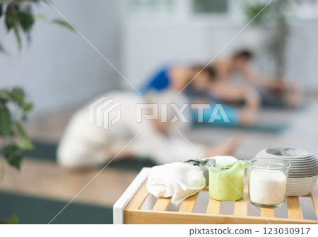 Towel, candles and aroma oil diffuser on table in yoga studio 123030917