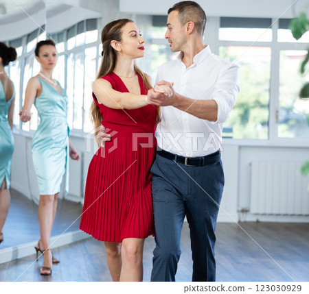 Elegant couple performing expressive tango in dance studio 123030929