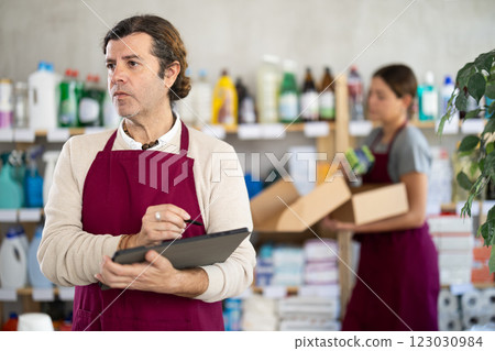 Household goods store owner using tablet to manage inventory 123030984