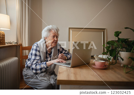 Senior woman working on laptop on her own, feeling confident. 123032425