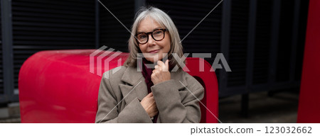 Elderly businesswoman stands confidently outside her office, showcasing professionalism during a 123032662