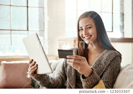 Tablet, online shopping and credit card, happy woman on couch on retail app and internet banking in home. Technology, cashback payment and girl on sofa with smile on ecommerce website or digital shop 123033307