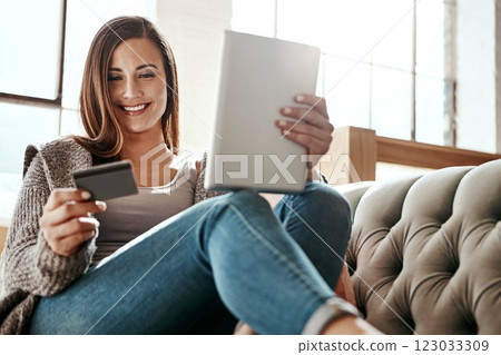 Payment, digital tablet and credit card by woman on a sofa, ecommerce and online shopping in her home. Girl, online shopping and relax checking debit card for purchase or subscription in living room 123033309