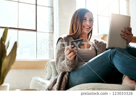 Online shopping, credit card and woman with digital tablet on a sofa, relax and smile while checking booking online. Ecommerce, girl and card for banking, credit score or subscription in living room 123033326