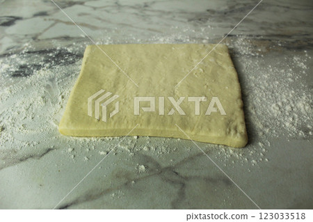 Piece of raw puff pastry on the table side view 123033518