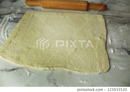rolled out plastic dough for making croissant cookies. Homemade cakes rolled out plastic dough for making croissant cookies. Homemade cakes 123033520
