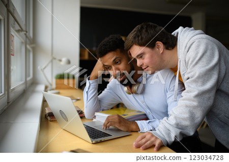 Tired young African-american teacher working on laptop. 123034728