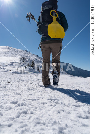 The feet of people walking on snowy mountains with crampons 123034915
