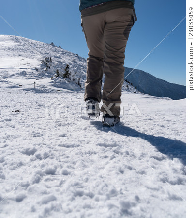 The feet of people walking on snowy mountains with crampons 123035059