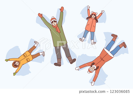 Family makes snow angels by lying on winter soil and moving arms and legs to sides. 123036085
