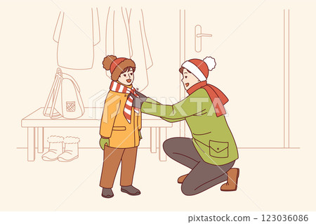 Caring father helps kid put on winter clothes so as not to freeze while walking along cold street Caring father helps kid put on winter clothes so as not to freeze while walking along cold street 123036086