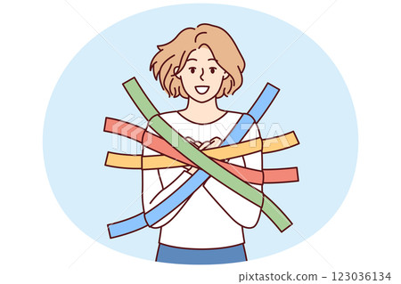 Positive girl smiles happily glued to wall with multi-colored adhesive tapes and is hostage 123036134