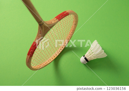 Wooden badminton rackets and white feather badminton shuttlecocks on green background. View from above. Close up. Copy space. Sports activity. 123036156