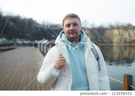 Happy bearded young man standing and smiling in wintertime outdoors Happy bearded young man standing and smiling in wintertime outdoors 123036423