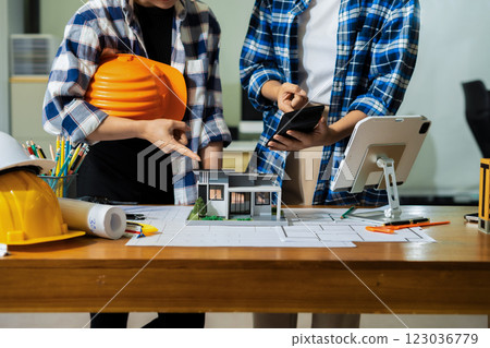 civil engineer or architect business useing calculator about calculate the cost with for working building plan design project in office. civil engineer or architect business useing calculator about calculate the cost with for working building plan design project in office. 123036779