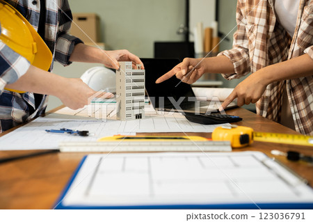 brainstorming and measuring for cost estimating on paperworks and floor plan drawings about design architectural and engineering for houses and buildings. 123036791