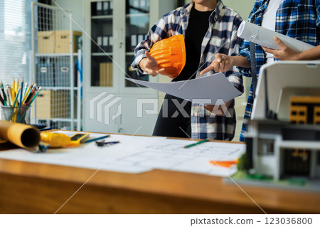 Engineer teams meeting working together wear worker helmets hardhat on construction site in modern city.Asian industry professional team. Engineer teams meeting working together wear worker helmets hardhat on construction site in modern city.Asian industry professional team. 123036800