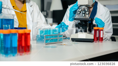 Medical or research scientist or doctor using looking at a test tube of clear solution in a lab or laboratory. Medical or research scientist or doctor using looking at a test tube of clear solution in a lab or laboratory. 123036816