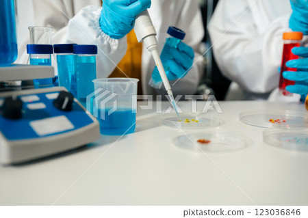 Team of biochemical research scientists working with a microscope for vaccine development Team of biochemical research scientists working with a microscope for vaccine development 123036846