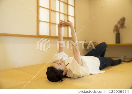 一名年輕女子躺在榻榻米上 123036924