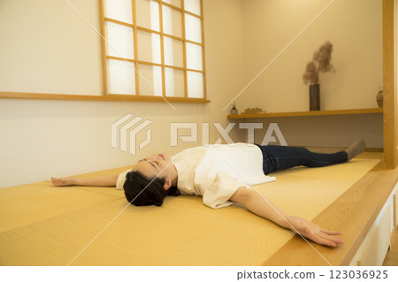 A young woman lying down on a tatami mat 123036925