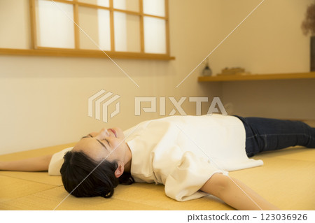 一名年輕女子躺在榻榻米上 一名年輕女子躺在榻榻米上 123036926