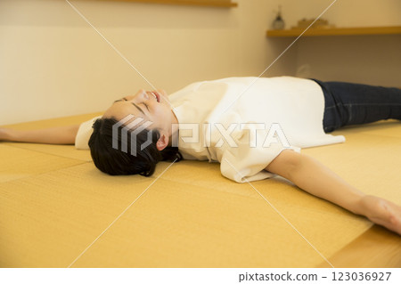 一名年輕女子躺在榻榻米上 一名年輕女子躺在榻榻米上 123036927