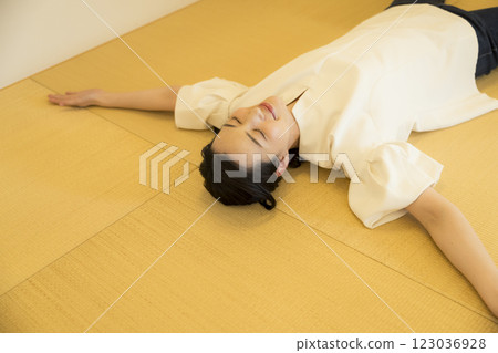 一名年輕女子躺在榻榻米上 123036928