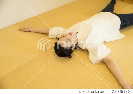 A young woman lying down on a tatami mat 123036930