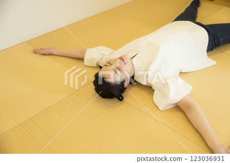 A young woman lying down on a tatami mat 123036931