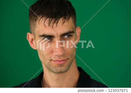 Young handsome businessman in light modern office.emotions of a handsome man guy on a green background chromakey close-up dark hair young man 123037871