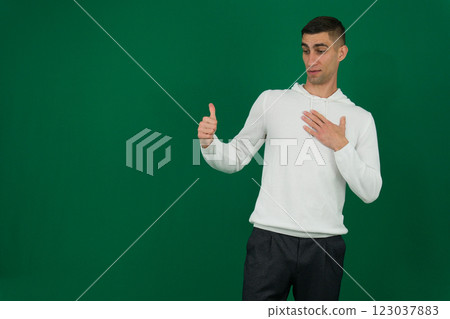 Attractive stylish man wearing white sweatshirt and sweatpants standing over blue studio background 123037883