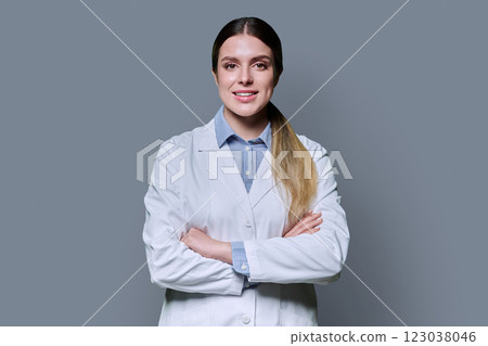 Portrait of young female student intern in white lab coat on gray background Portrait of young female student intern in white lab coat on gray background 123038046