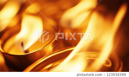 Warm candles flickering in soft light for ambiance 123038399
