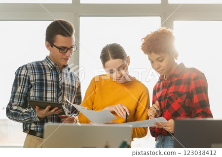 Teamwork brainstorm young professional team concept. Happy multiracial coworkers cooperating working together at office meeting. Diverse colleagues discussing project ideas editing documentation 123038412
