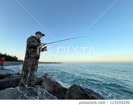Young happy woman and old man is fishing at sea during spring vacation Young happy woman and old man is fishing at sea during spring vacation 123039206
