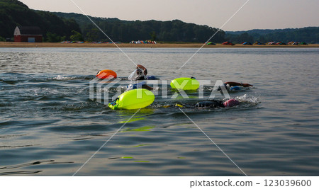 Swimmers Practicing in Open Water With Buoyancy Aids on a Calm Summer Day 123039600