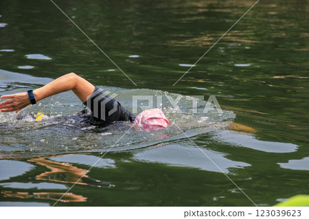 Swimmer Practicing Freestyle Stroke in Calm Lake Water During Early Morning 123039623
