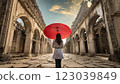 在古雅的歐式建築中，一位撐著紅傘的女子在雨中 123039849