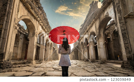 在古雅的歐式建築中，一位撐著紅傘的女子在雨中 123039849
