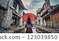 在古雅的歐式建築中，一位撐著紅傘的女子在雨中 123039850
