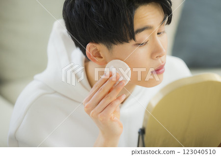 Young man looking in the mirror in his living room 123040510