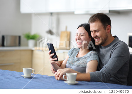 Happy interracial couple laughing checking smart phone 123040970